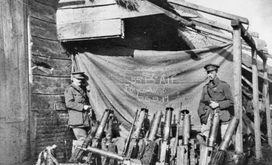 Two Australian officers with some of the German machine guns captured by the 55th Battalion in the attack near Ypres by the 5th Division on 26 September 1917 (AWM C01085).