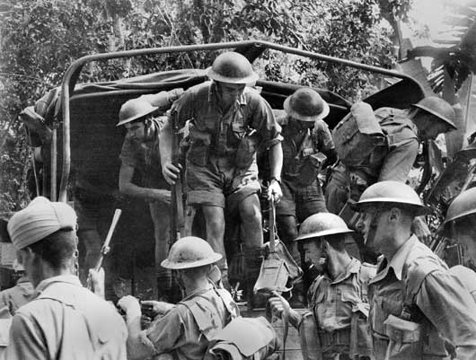 Australian troops alighting from a truck during the Allied retreat to Singapore (AWM 011303/29).