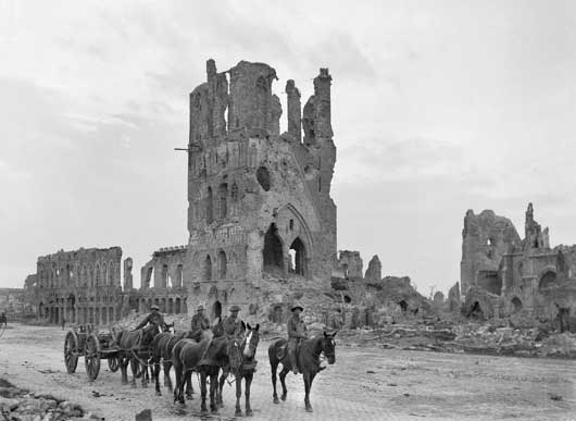 A loaded limber passing the ruins of the Cloth Hall at Ypres (AWM E00717).